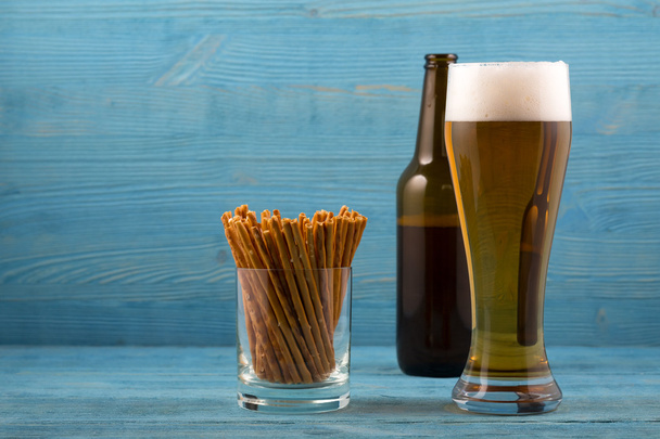 Пиво и соленые палочки на синем фоне
 - Фото, изображение