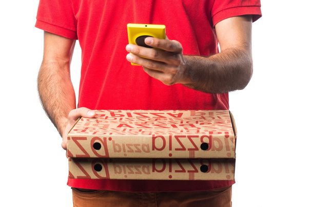 Pizza levering man met een mobiele - Foto, afbeelding