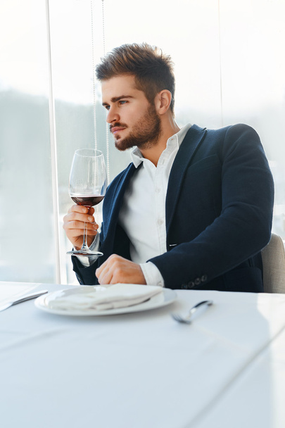 Drink. Handsome Man Drinking Wine In Restaurant. Business Man Su - Фото, изображение