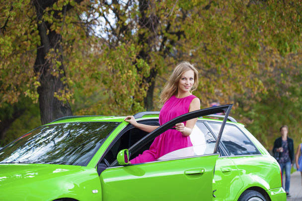 Portrait of a beautiful blonde woman and green sports car - Foto, Imagem