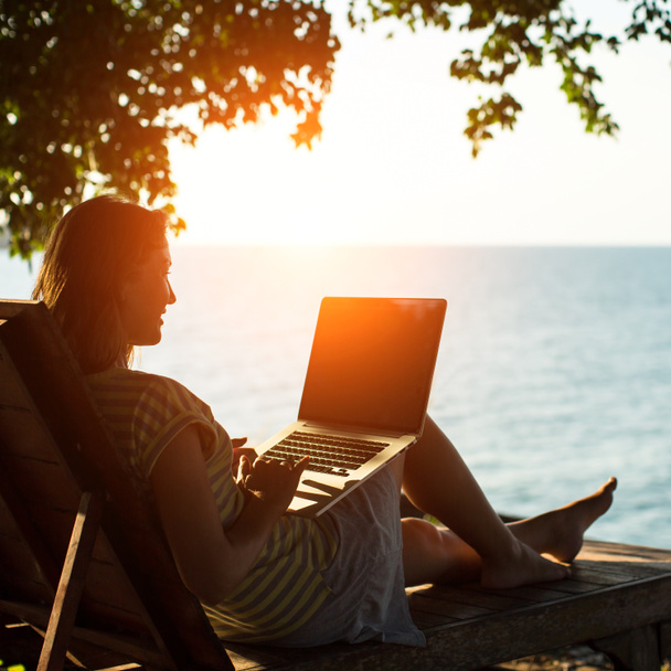 Frau auf einer Sonnenliege mit Laptop - Foto, Bild