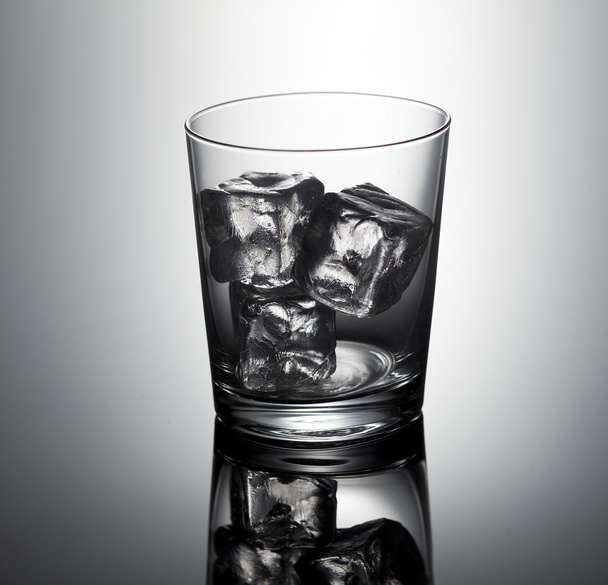 Empty whiskey glass with ice cubes - 写真・画像