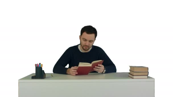 Young and concentrated student reads a book on white background isolated - 映像、動画