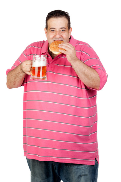 Fat man drinking a jar of beer and eating hamburger - Photo, Image