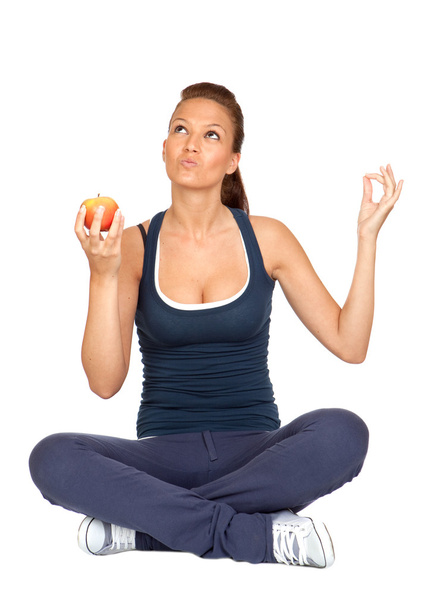 Gymnastics girl with an apple sitting with cross-legs - Foto, immagini