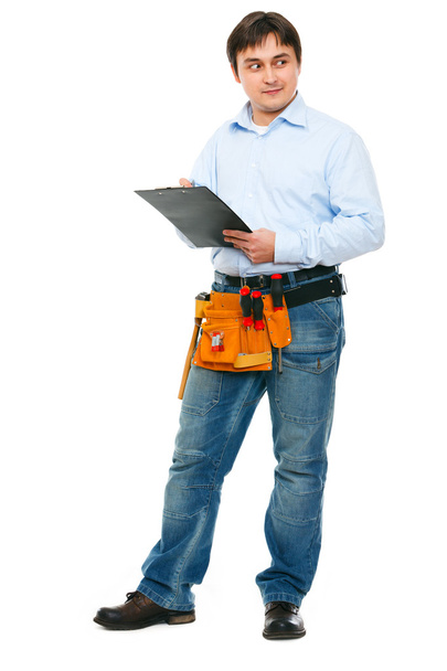 Construction worker with clipboard looking on side - Foto, afbeelding