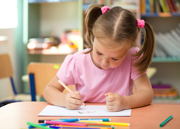 Cute little girl is drawing with felt-tip pen - Foto, afbeelding
