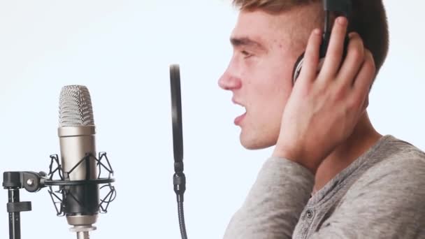 Jóképű fickó énekel egy mikrofon állandó stúdió fejhallgató. Hangstúdió. - Felvétel, videó