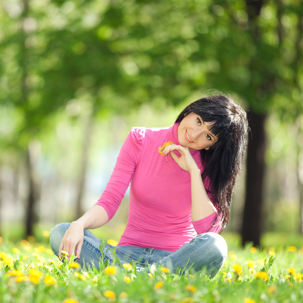 Cute woman in the park with dandelions - Foto, imagen