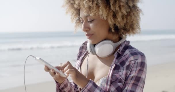 Chica escuchando música en la playa
 - Metraje, vídeo