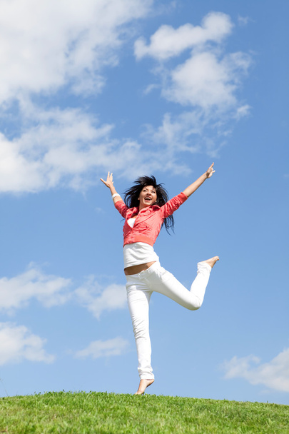 hübsche junge Frau springt auf grünem Gras - Foto, Bild