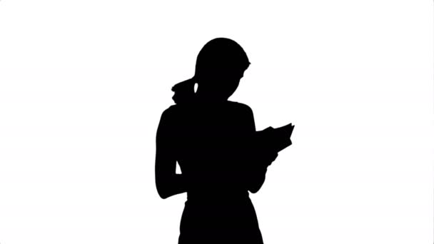 Silhouette Young girl with book on laptop - Filmati, video