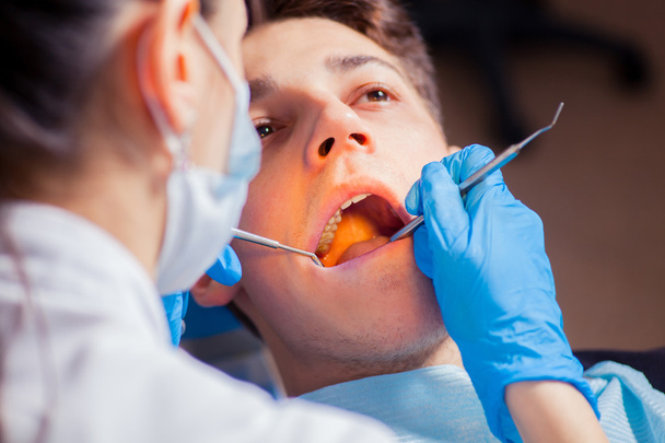 Man having teeth examined at dentists dental treatment - Foto, imagen