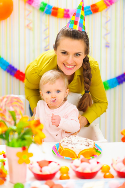 Smiling mother and eat smeared baby on birthday celebration part - 写真・画像