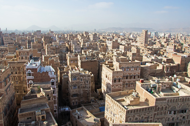 Yemen, Middle East: aerial view of the skyline of the capital Sana'a, Unesco world heritage site, with its minarets, mosques and unique palaces and stone tower houses decorated with geometric patterns of fired bricks and white gypsum - Photo, Image