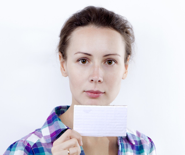 A beautiful casual young woman holding a blank business card in  - Fotó, kép
