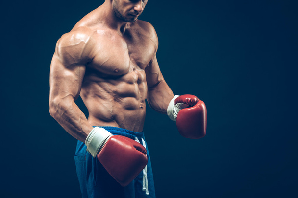 Muscular boxer in studio shooting, on black background. - Foto, Imagen