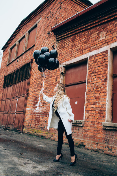 girl in trendy clothes with black balloons - Фото, зображення