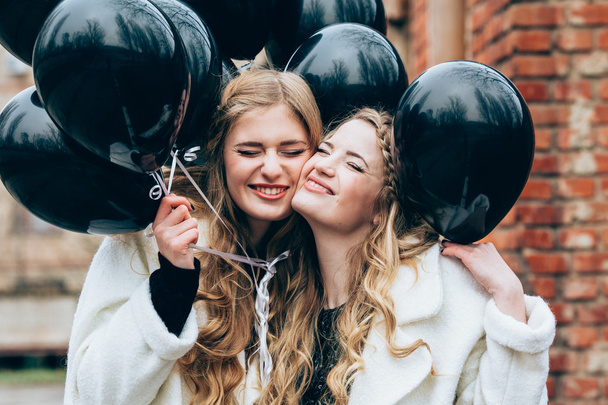 hermosas chicas con globos negros
 - Foto, Imagen