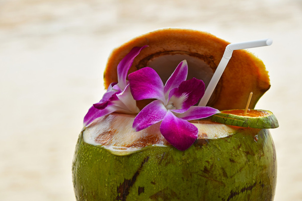 Verse melk van kokosnoot sap versierd met bloemen - Foto, afbeelding