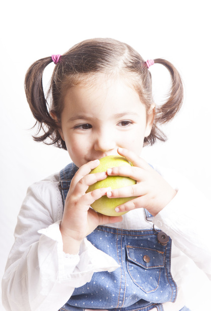 Mała dziewczynka gryzienie zielonego jabłka - Zdjęcie, obraz