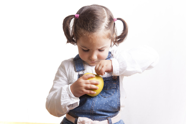 Porträt eines glücklichen Mädchens mit einem gelben Apfel - Foto, Bild