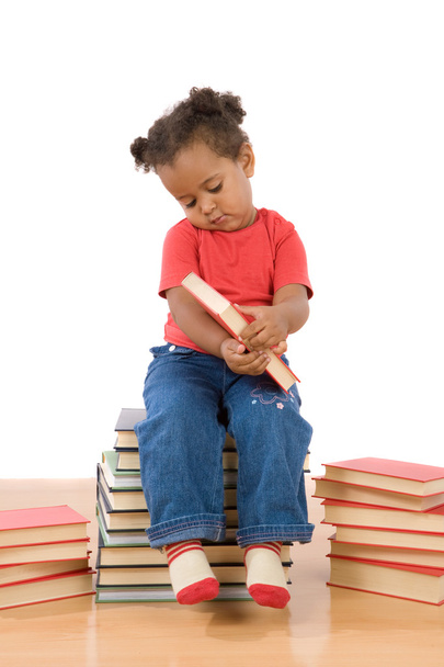 Bambino che legge seduto su un mucchio di libri
 - Foto, immagini