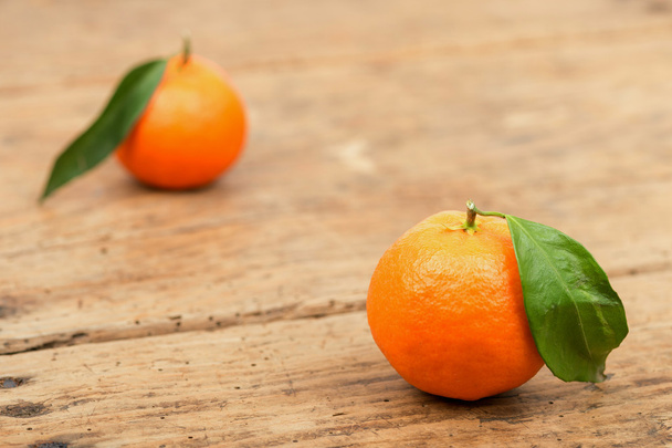 Owoce świeże mandarynki z liści w starym drewnianym stole - Zdjęcie, obraz