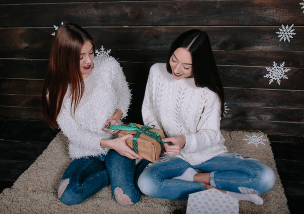 zwei schöne Mädchen packen gemeinsam Geschenke aus - Foto, Bild