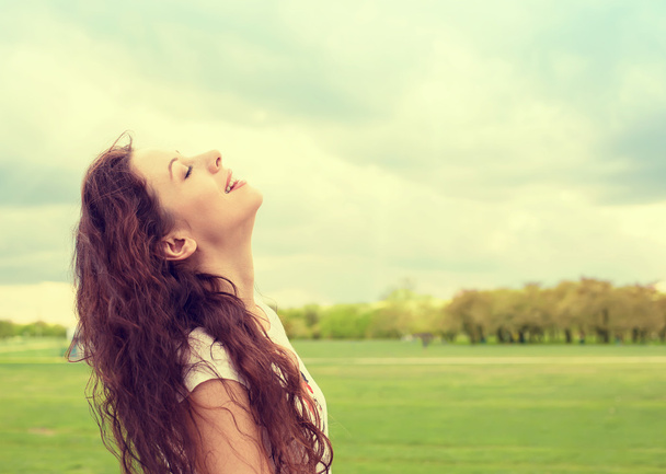 woman smiling looking up to blue sky celebrating enjoying freedom - Foto, immagini