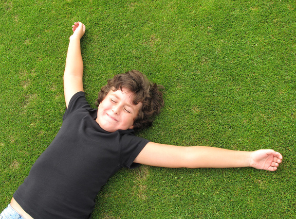 Bambino felice che riposa sull'erba
 - Foto, immagini