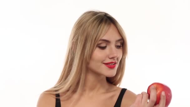 Mujer de belleza comiendo manzana fresca y jugosa en fondo blanco
 - Imágenes, Vídeo