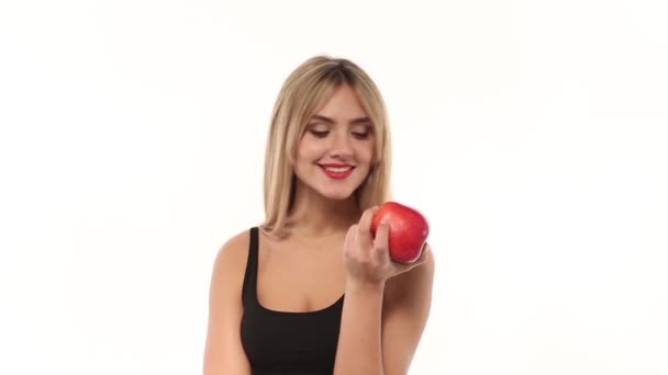 Krása ženy jíst čerstvé a šťavnaté jablko na bílém pozadí - Záběry, video