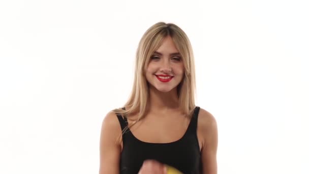 Vrouw zoete bananen eten op witte achtergrond - Video