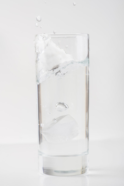 Glass of water with ice on white surface. - Photo, Image