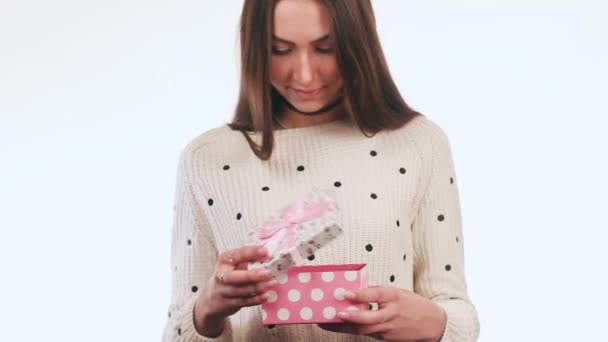 Velmi krásná dívka otevírá dárek. Je velmi šťastná. Ona se usmívá a směje se. - Záběry, video