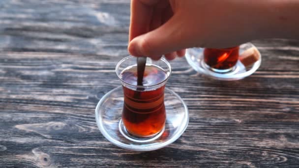 Gieten van thee in een beker op een houten tafel - Video