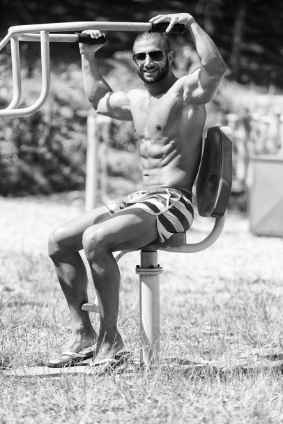 Muscular Man Training On The Playground In Park - 写真・画像