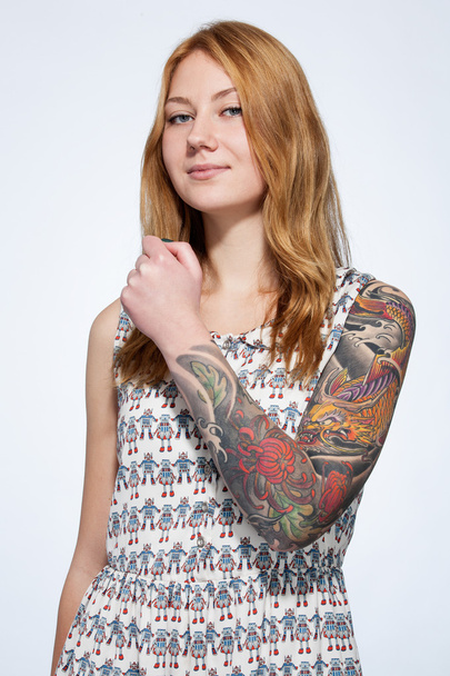 πορτρέτο του ένα χαμογελαστό νεαρή γυναίκα τζίντζερ προβολή τατουάζ στην h - Φωτογραφία, εικόνα