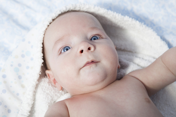 Boldog baba fiú becsomagolt fürdőlepedő után fürdő az ágyban otthon - Fotó, kép