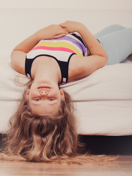 Little girl kid with long hair upside down on sofa - Fotografie, Obrázek