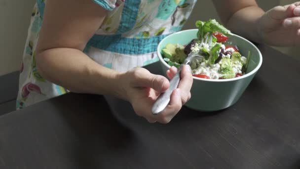Een vrouw geniet een salade zittend - Video