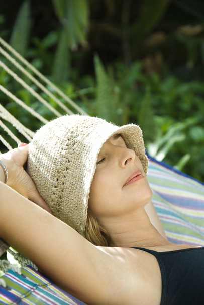 Woman relaxing in hammock. - 写真・画像