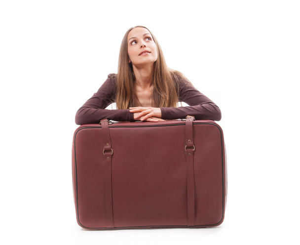 Girl sitting near a suitcase, isolated on white - Foto, afbeelding