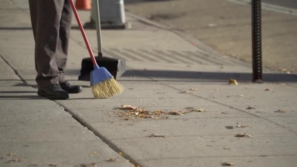 During the day a person sweeps a sidewalk - Footage, Video