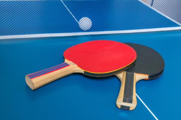 Raquetas para jugar al tenis de mesa frente a una red
. - Foto, imagen