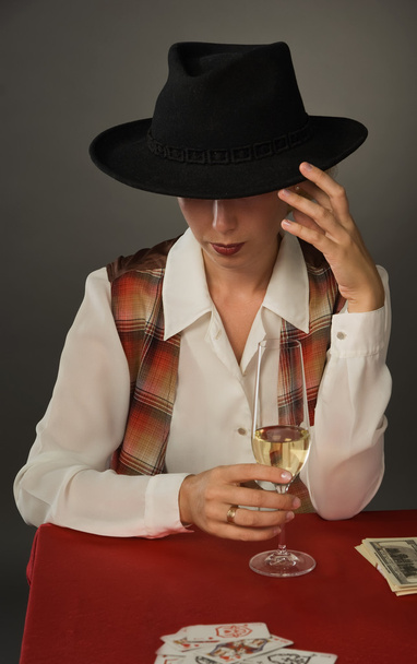 piękna kobieta w czarnym kapeluszu przy lampce wina - Zdjęcie, obraz