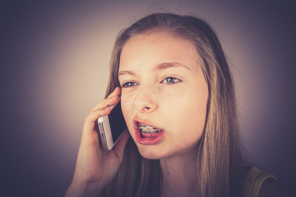 Teenage girl telephoned indignantly, grain effect - Valokuva, kuva
