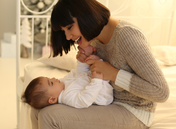 hermosa madre con pelo corto oscuro y su pequeño bebé lindo
  - Foto, Imagen