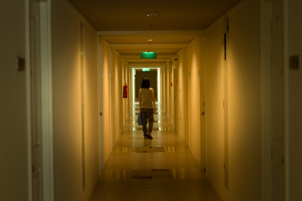 ホテルの廊下を歩いてぼやけアジア女性. - 写真・画像